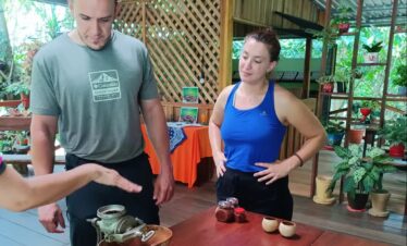 Couple learning how to grind cacao to make chocolate