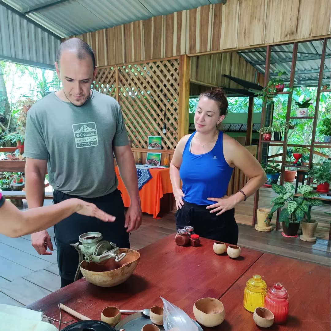 Couple learning how to grind cacao to make chocolate