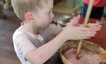 Young boy blending cacao traditionally