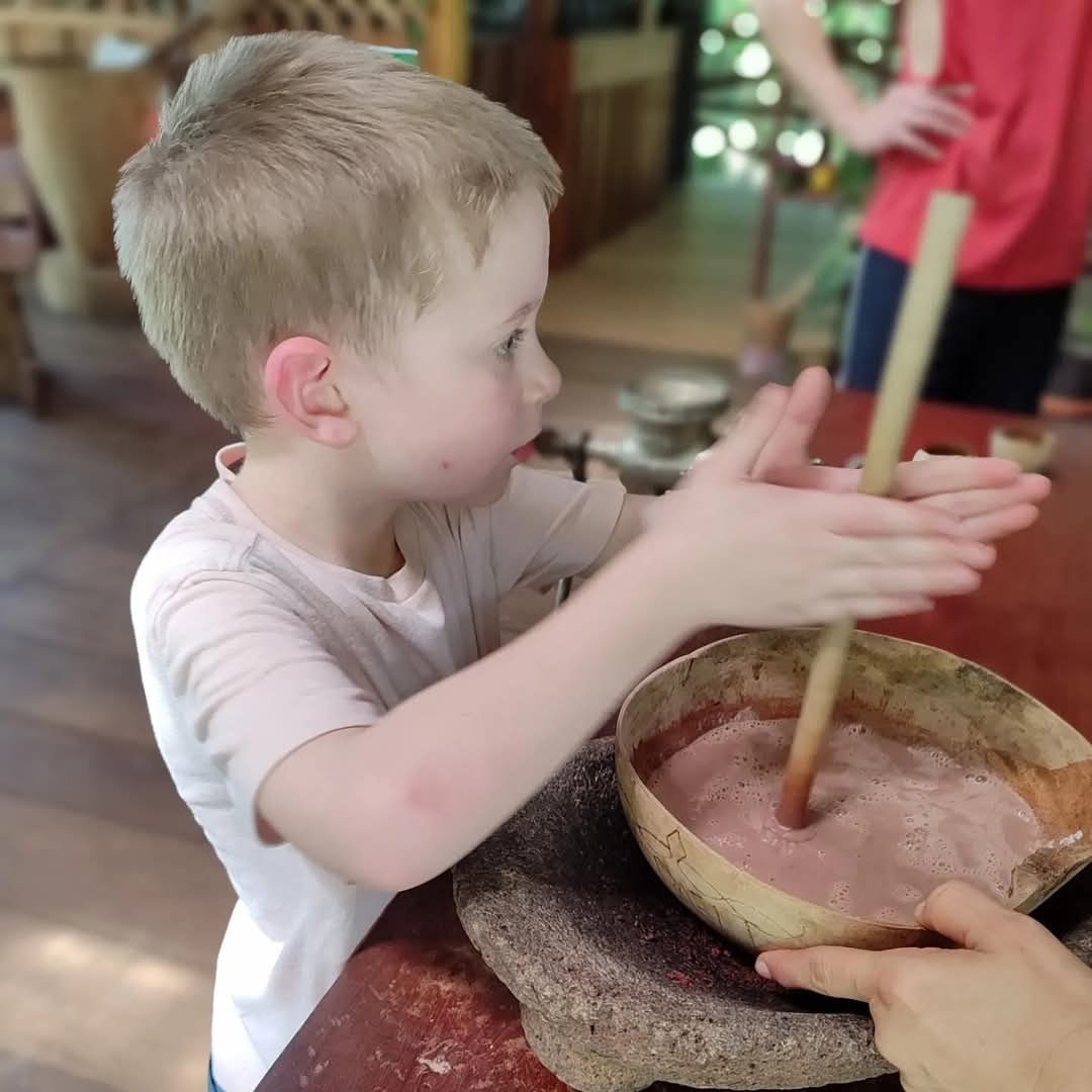 Young boy blending cacao traditionally
