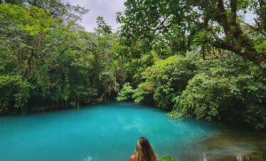 Woman marveling at the color of Rio Celeste