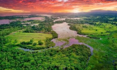 Aerial view of Caño Negro lush green and colorful sunset