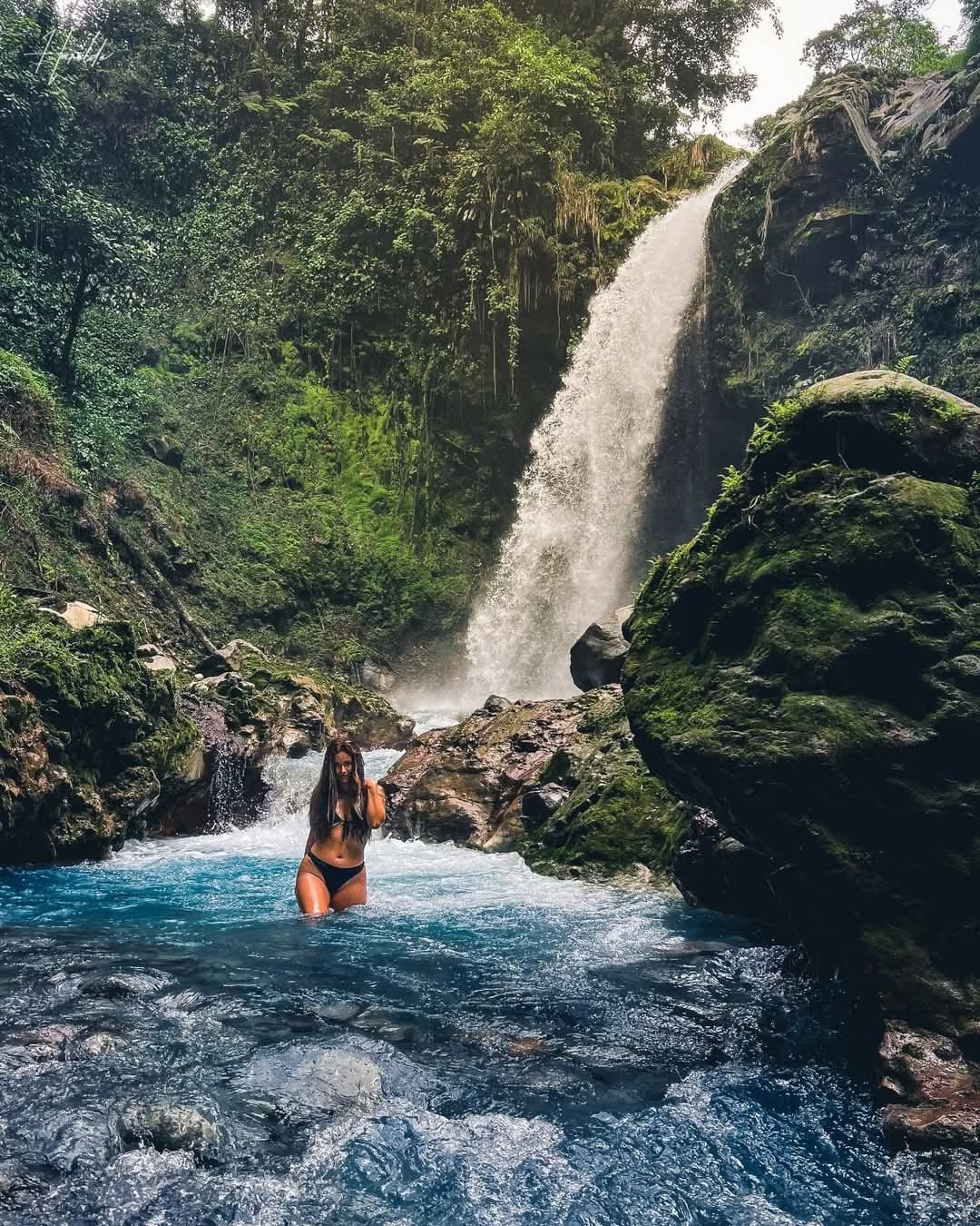 Woman bathing in the waterfall Morpho Azul in Upala, Costa Rica